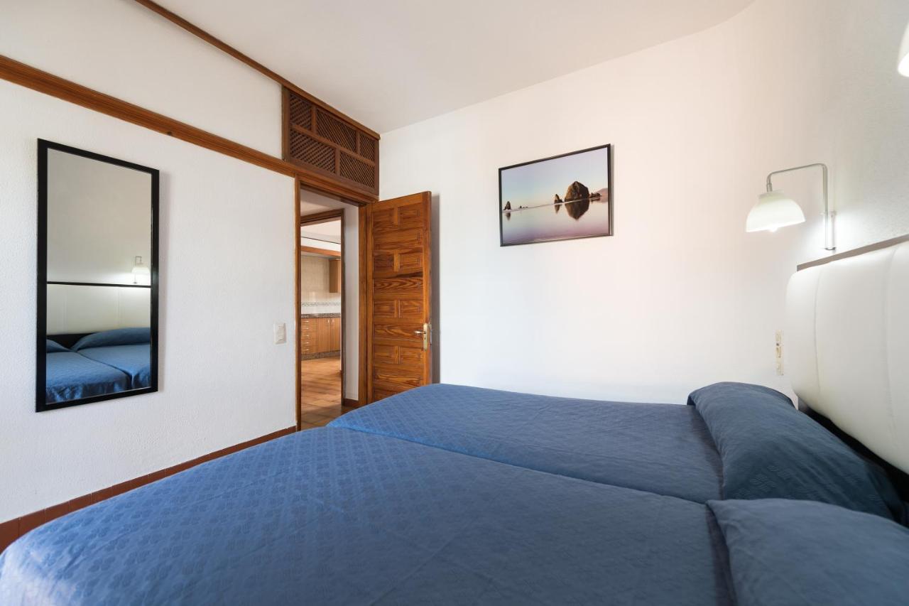 een slaapkamer met een blauw bed en een spiegel bij Apartamentos Don Pedro in Playa del Inglés