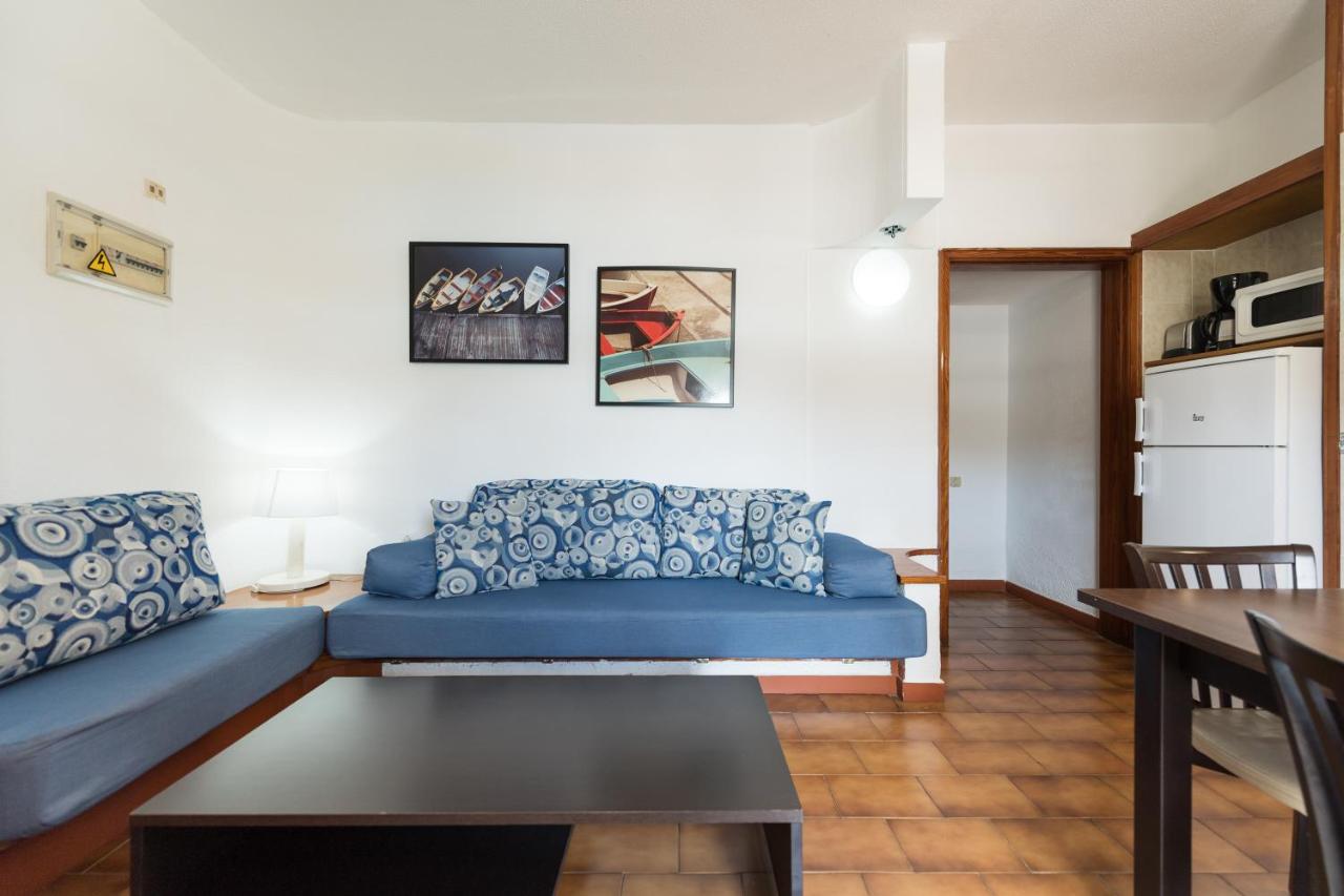 een woonkamer met een blauwe bank en een tafel bij Apartamentos Don Pedro in Playa del Inglés