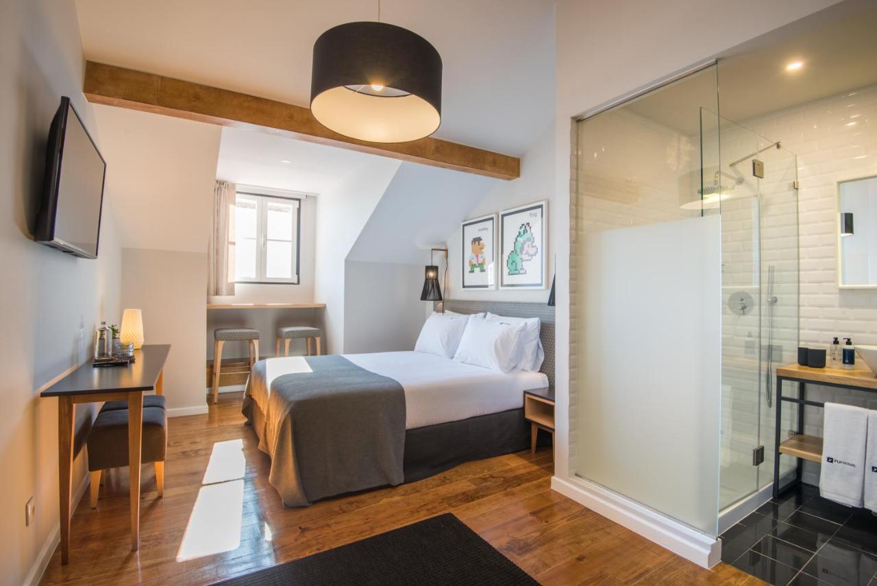 een hotelkamer met een bed en een douche bij Urbano FLH Hotels Lisboa in Lissabon