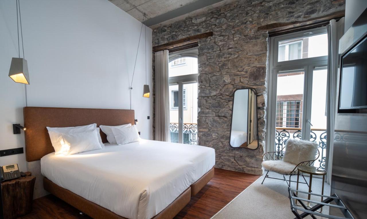 een slaapkamer met een bed en een balkon bij Hotel Cajú in Funchal