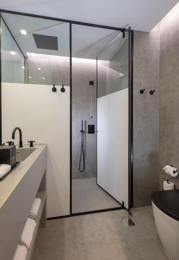 een badkamer met een douche, een bad en een wastafel bij Hotel Cajú in Funchal