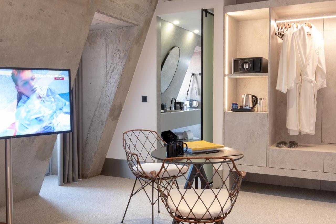 een woonkamer met een tv en een tafel met een stoel bij Hotel Cajú in Funchal