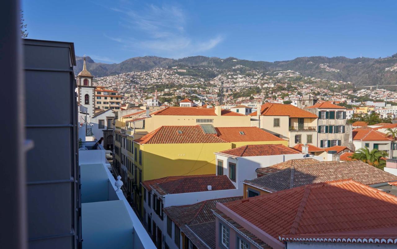 een uitzicht op een stad met gebouwen en bergen bij Hotel Cajú in Funchal