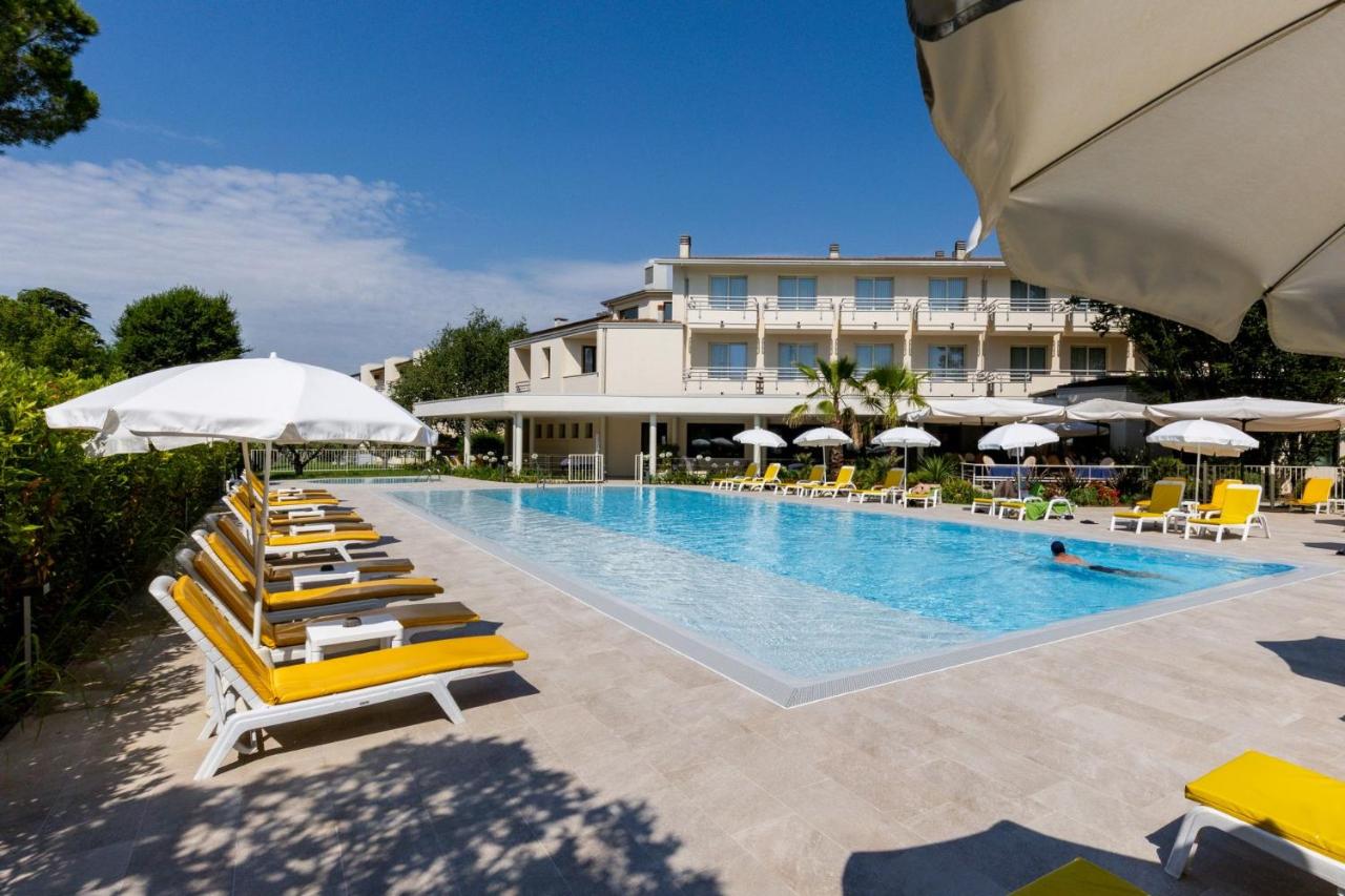 een zwembad met ligstoelen en parasols en een hotel bij Hotel Du Parc in Sirmione