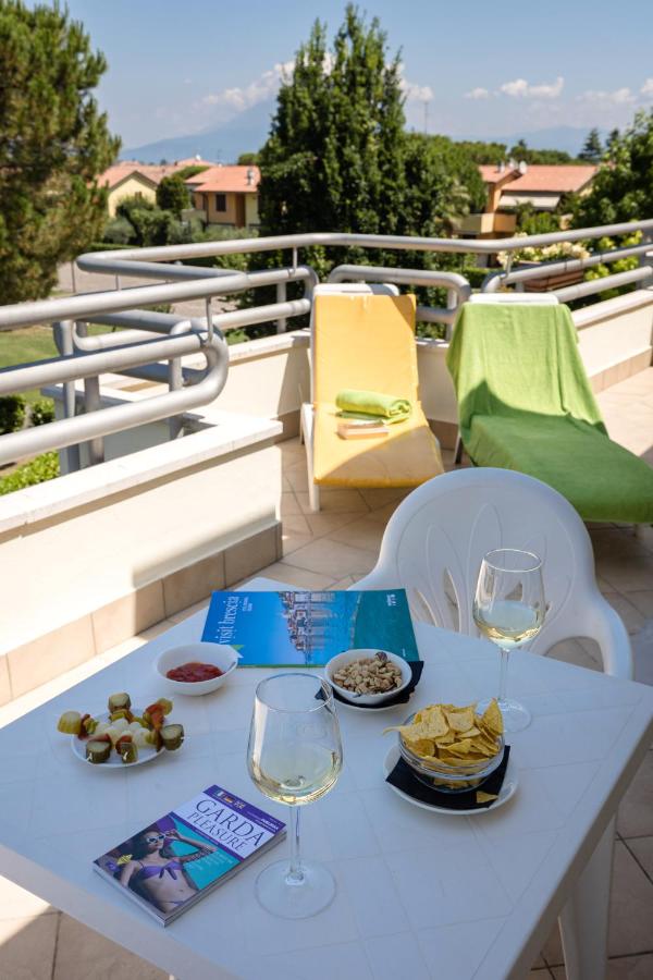een tafel met wijnglazen en eten op een balkon bij Hotel Du Parc in Sirmione