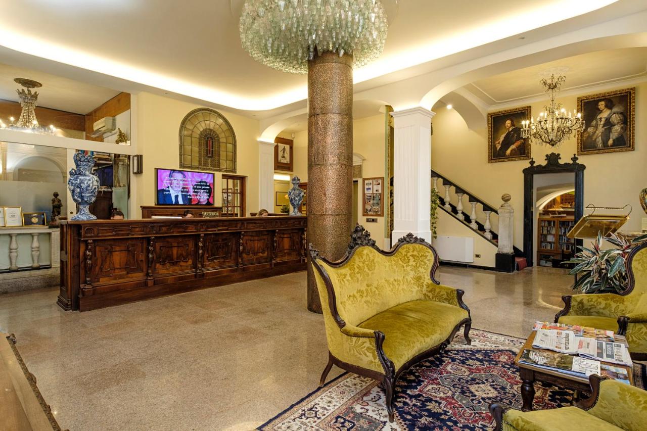 een woonkamer met een stoel en een kroonluchter bij Hotel Due Mari in Sestri Levante