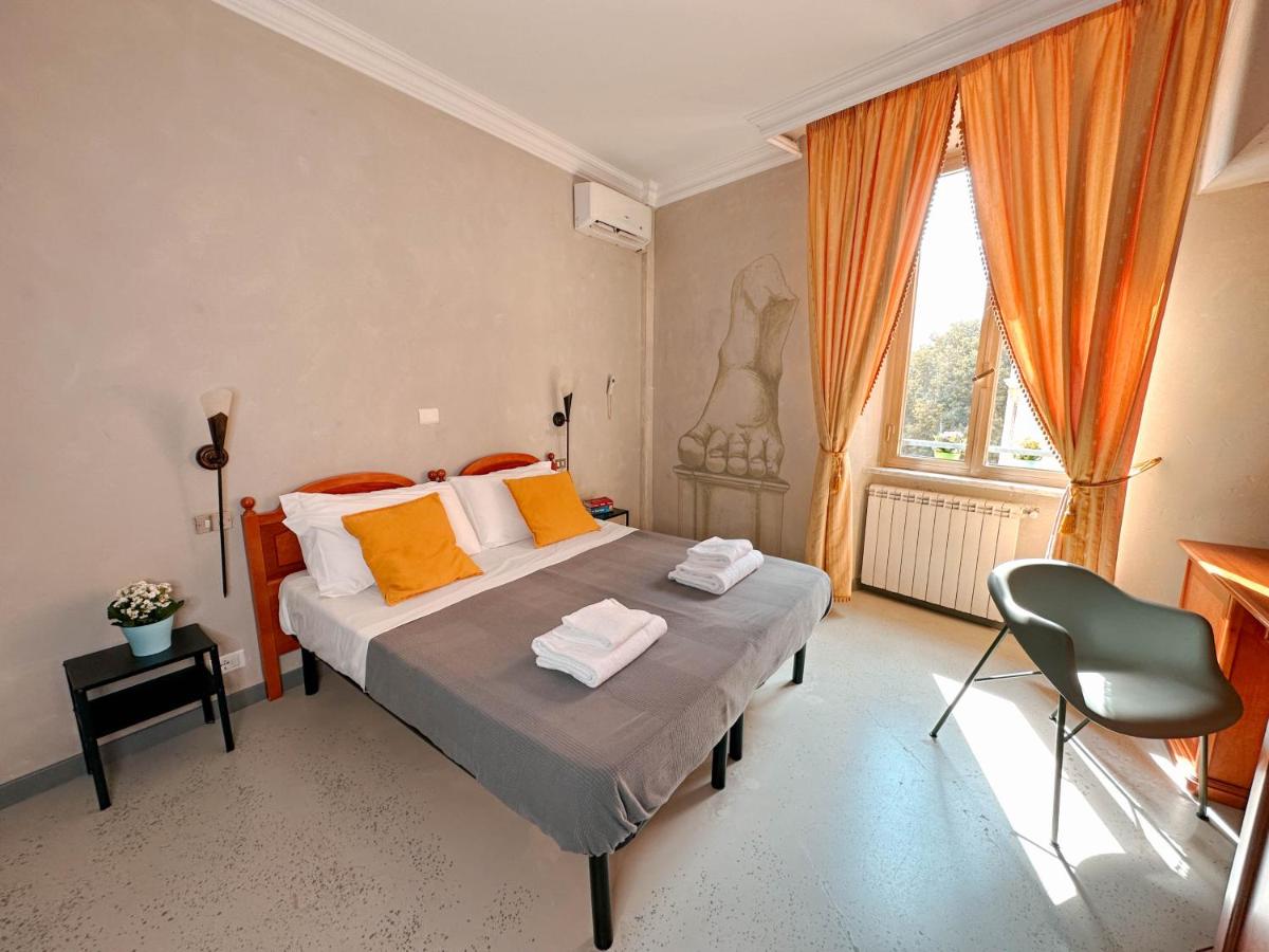 een slaapkamer met een bed met oranje kussens en een raam bij Ostello Bello Roma Colosseo in Rome