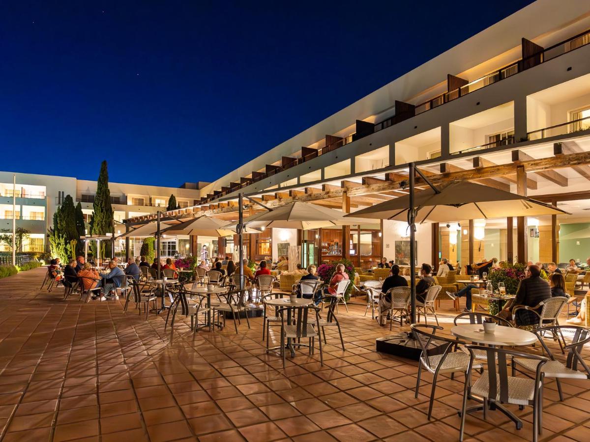 een groep tafels en stoelen voor een gebouw bij Hotel Fuerte Conil-Resort in Conil de la Frontera