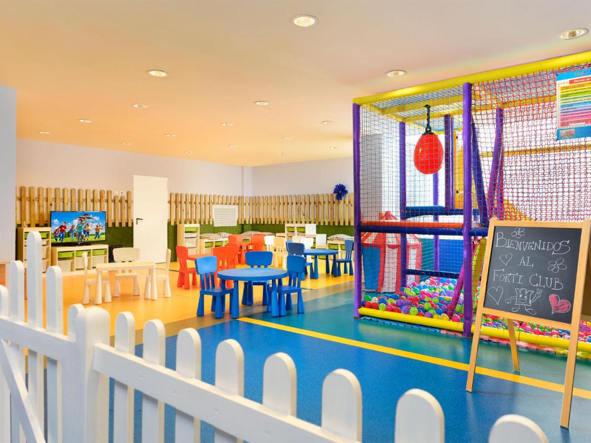 een klaslokaal met een tafel, stoelen en een schoolbord bij Hotel Fuerte Conil-Resort in Conil de la Frontera