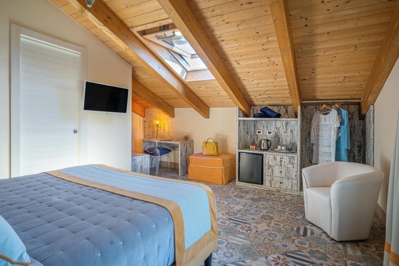 een slaapkamer met een bed, een televisie en een stoel bij DON GIULIO LUXURY ROOMS jacuzzi in Vico Equense