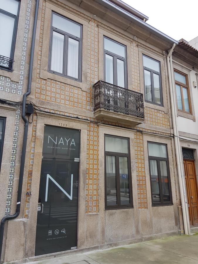 een bakstenen gebouw met een deur en een balkon bij Naya-Downtown Guesthouse in Porto
