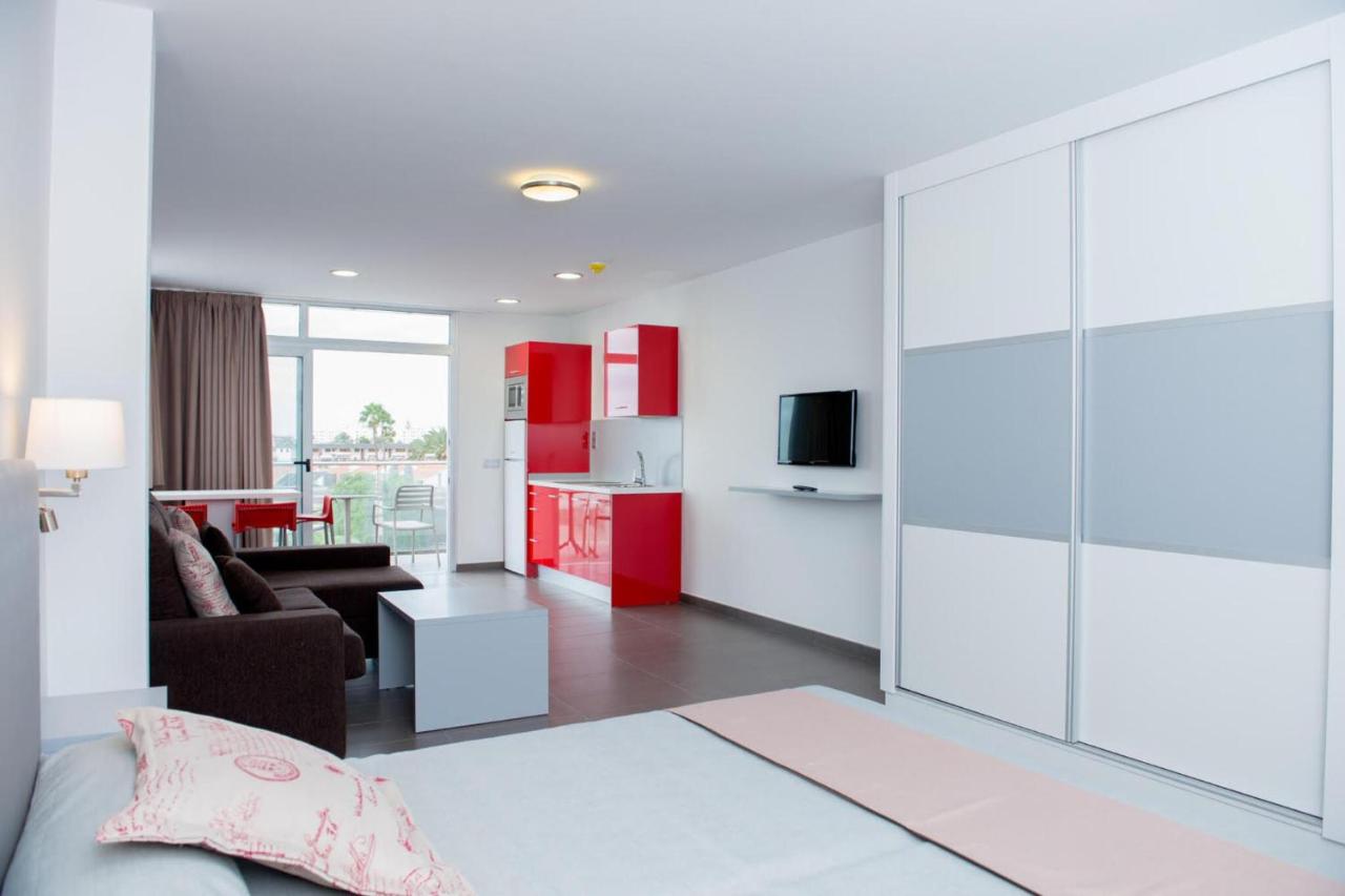 een woonkamer met een grote schuifdeur van glas bij Apartamentos El Palmar in Playa del Inglés