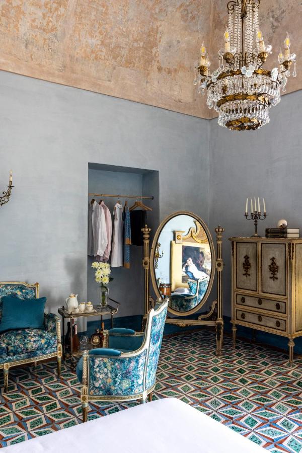 een kamer met stoelen, een spiegel en een kroonluchter bij Villa De Cillis Carafa in Torre del Greco