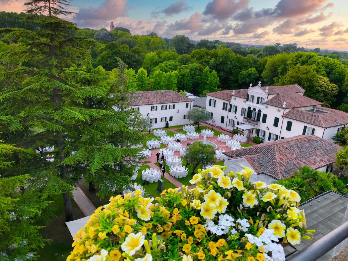 een groep witte gebouwen met bloemen op de voorgrond bij Park Hotel Villa Fiorita in Monastier di Treviso