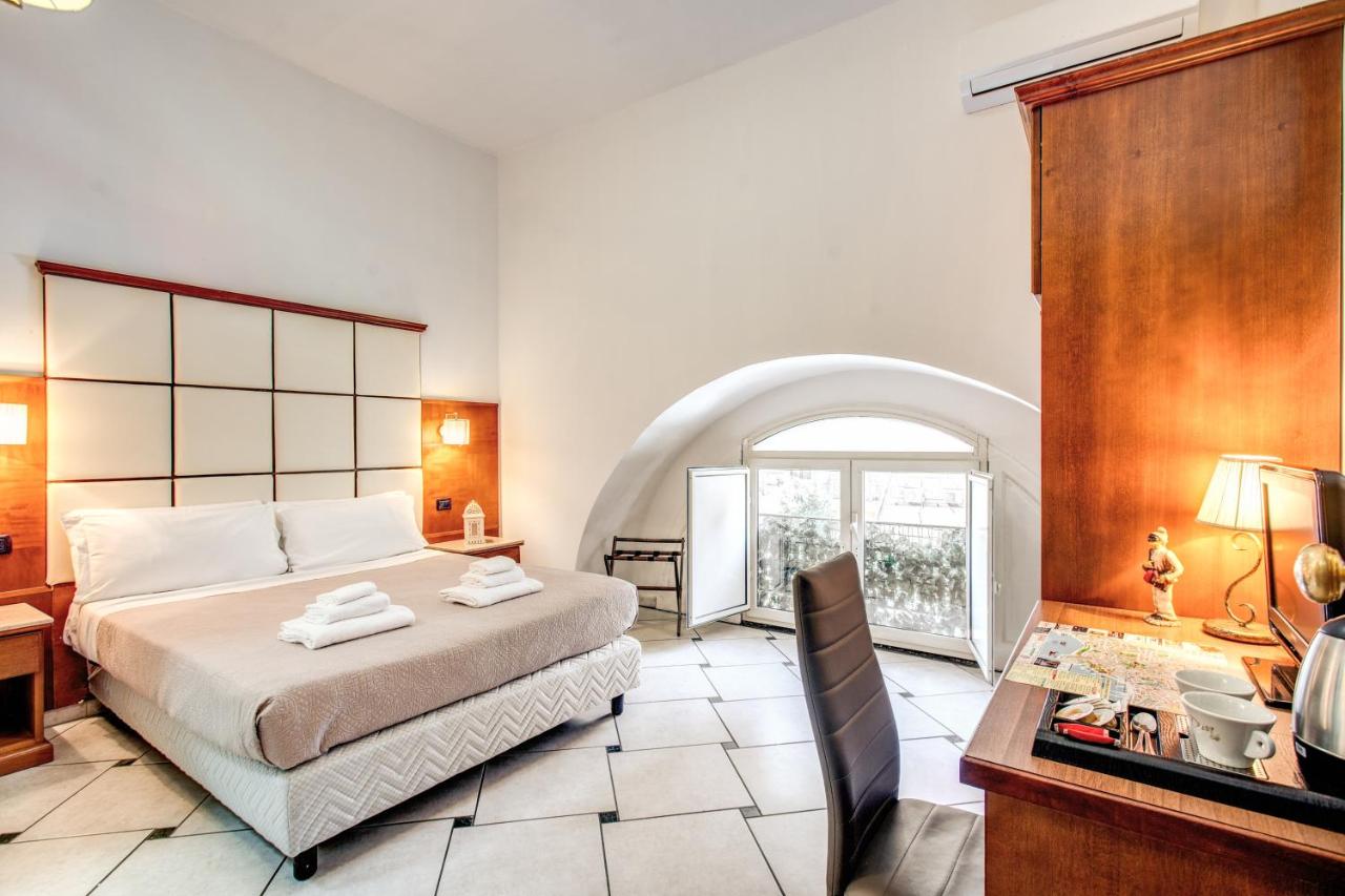 een slaapkamer met een bed, een bureau en een raam bij Garibaldi Suite in Napels