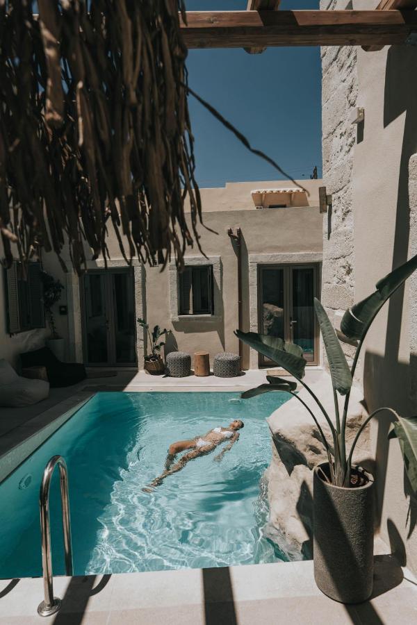 een persoon die zwemt in een zwembad in een huis bij Manili Boutique Suites & Villas, an SLH Hotel in Archanes