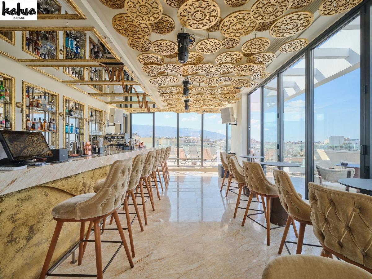 een bar met stoelen, tafels en ramen bij NYX Esperia Palace Hotel Athens by Leonardo Hotels in Athene