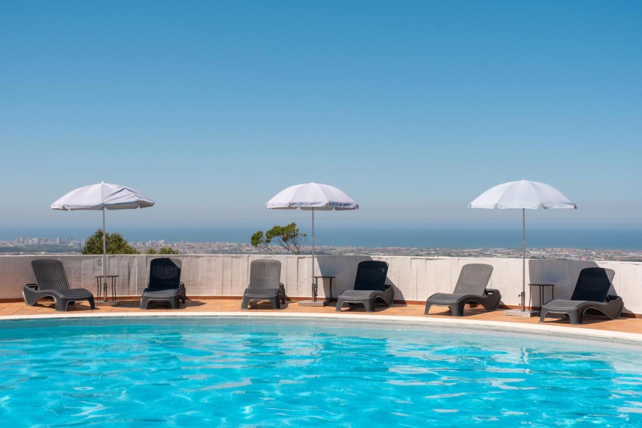 een zwembad met ligstoelen en parasols bij Sao Felix Hotel Hillside & Nature in Póvoa de Varzim
