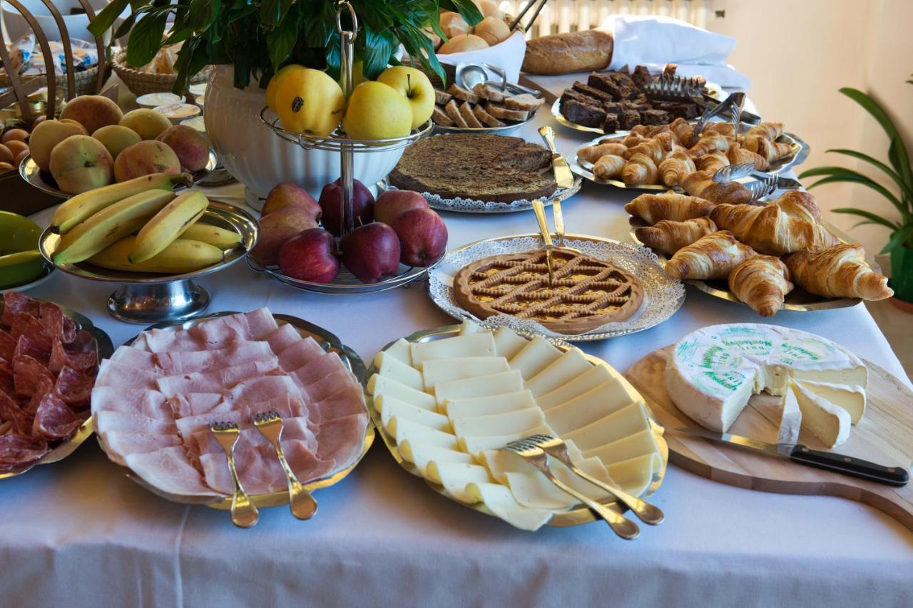 een tafel vol met allerlei verschillende soorten eten bij Hotel Europa in Porlezza