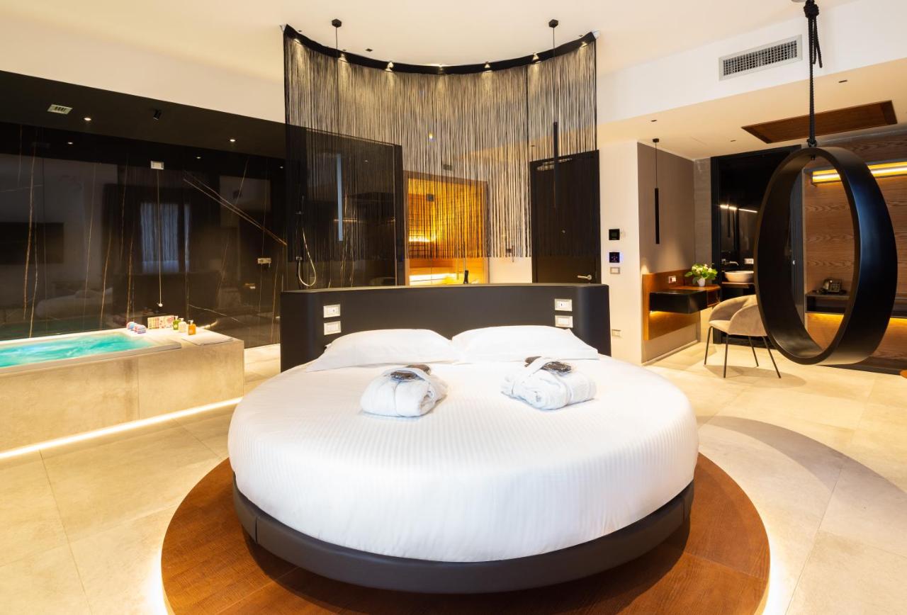 een slaapkamer met een groot bed en een badkuip bij The Corner Duomo Hotel in Milaan