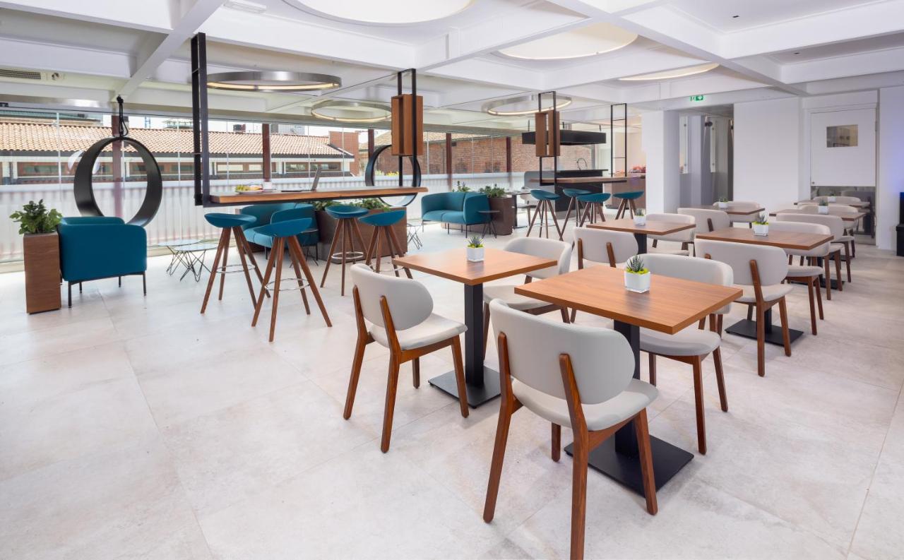 een restaurant met tafels en stoelen en een bar bij The Corner Duomo Hotel in Milaan