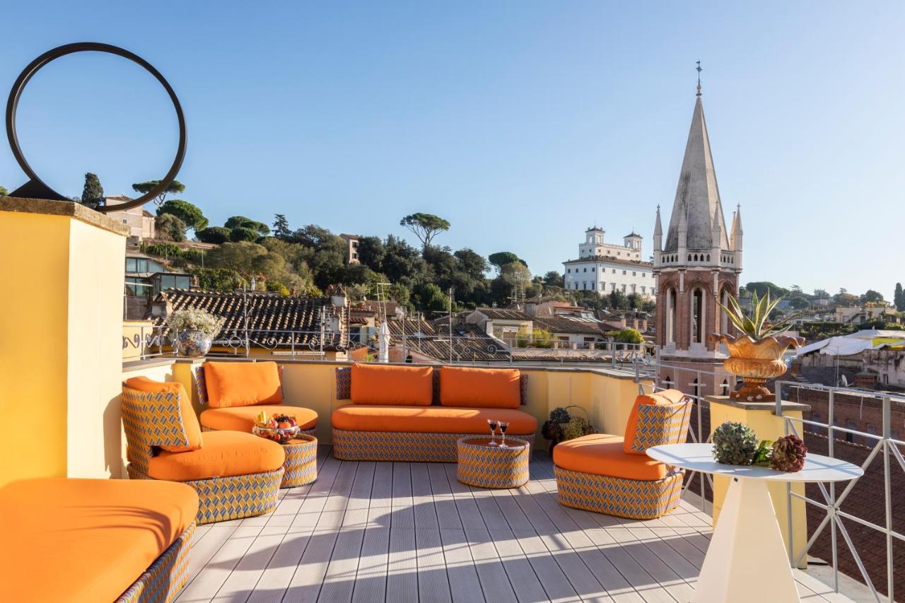 een balkon met oranje meubilair en uitzicht op een kerk bij Poēsis Experience Hotel in Rome