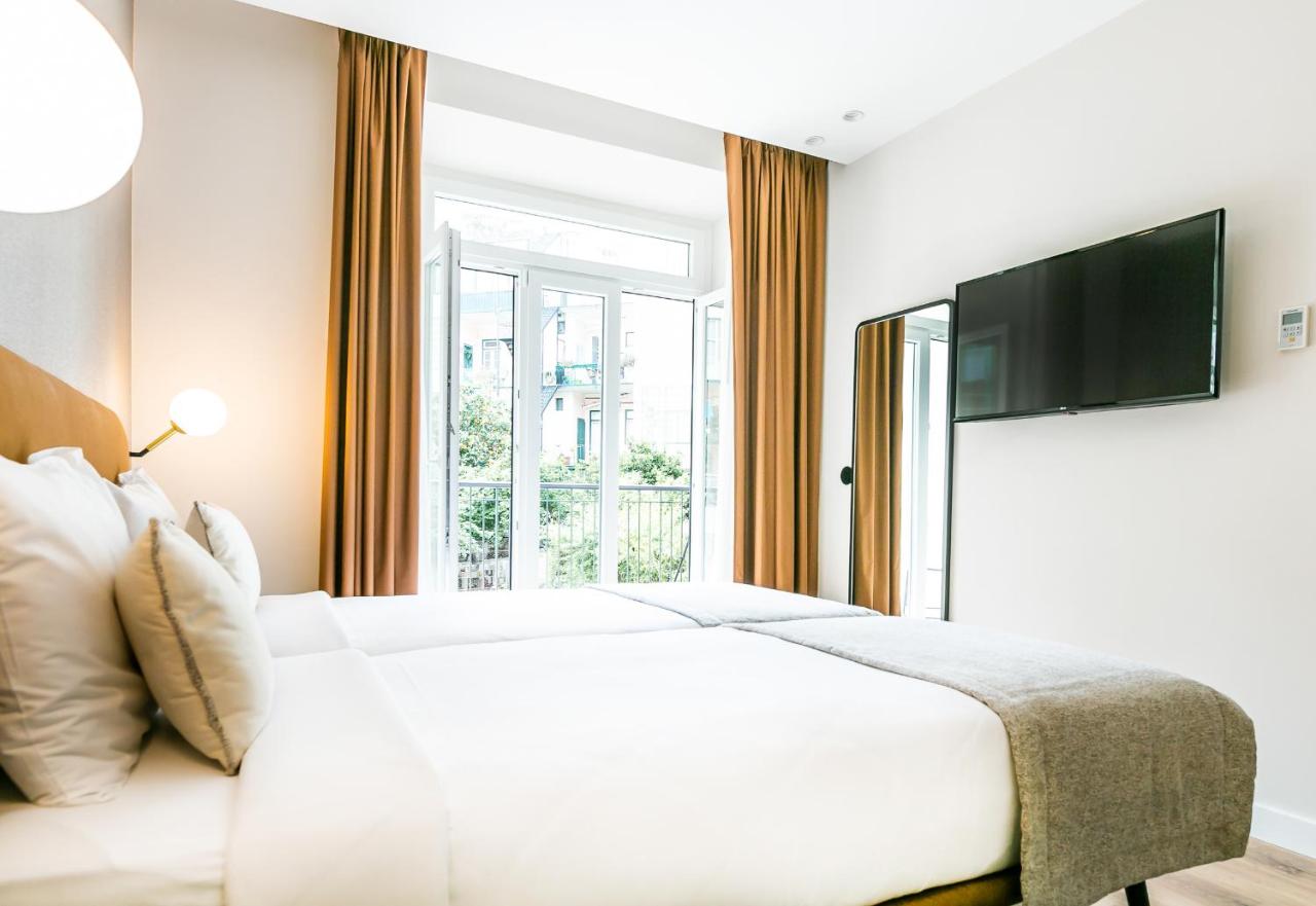 een witte slaapkamer met een groot bed en een raam bij LX SoHo Boutique Hotel by RIDAN Hotels in Lissabon +34 foto's