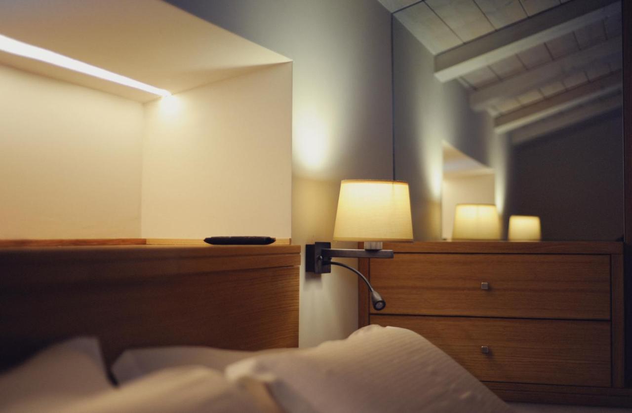 een slaapkamer met een bed, een lamp en een spiegel bij Dimora del Campo in Matera