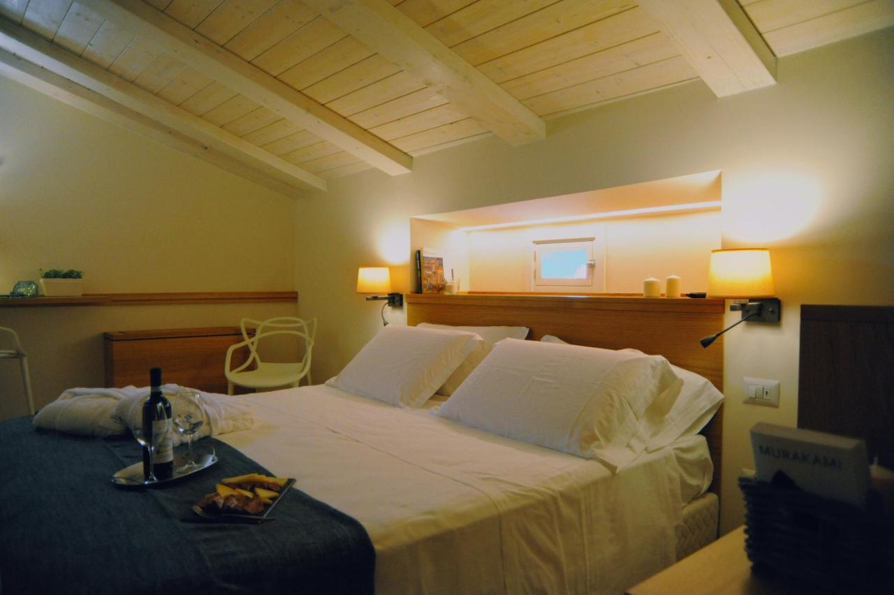 een slaapkamer met een groot wit bed en een tafel bij Dimora del Campo in Matera
