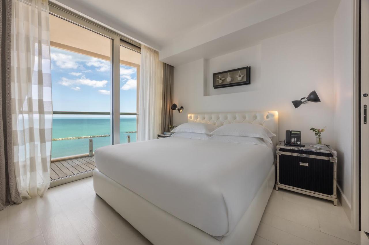 een slaapkamer met een groot wit bed en een groot raam bij Excelsior Hotel, SPA & Lido - Preferred Hotels & Resorts in P