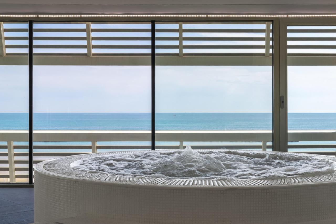 een grote witte tafel met uitzicht op de oceaan bij Excelsior Hotel, SPA & Lido - Preferred Hotels & Resorts in Pesaro