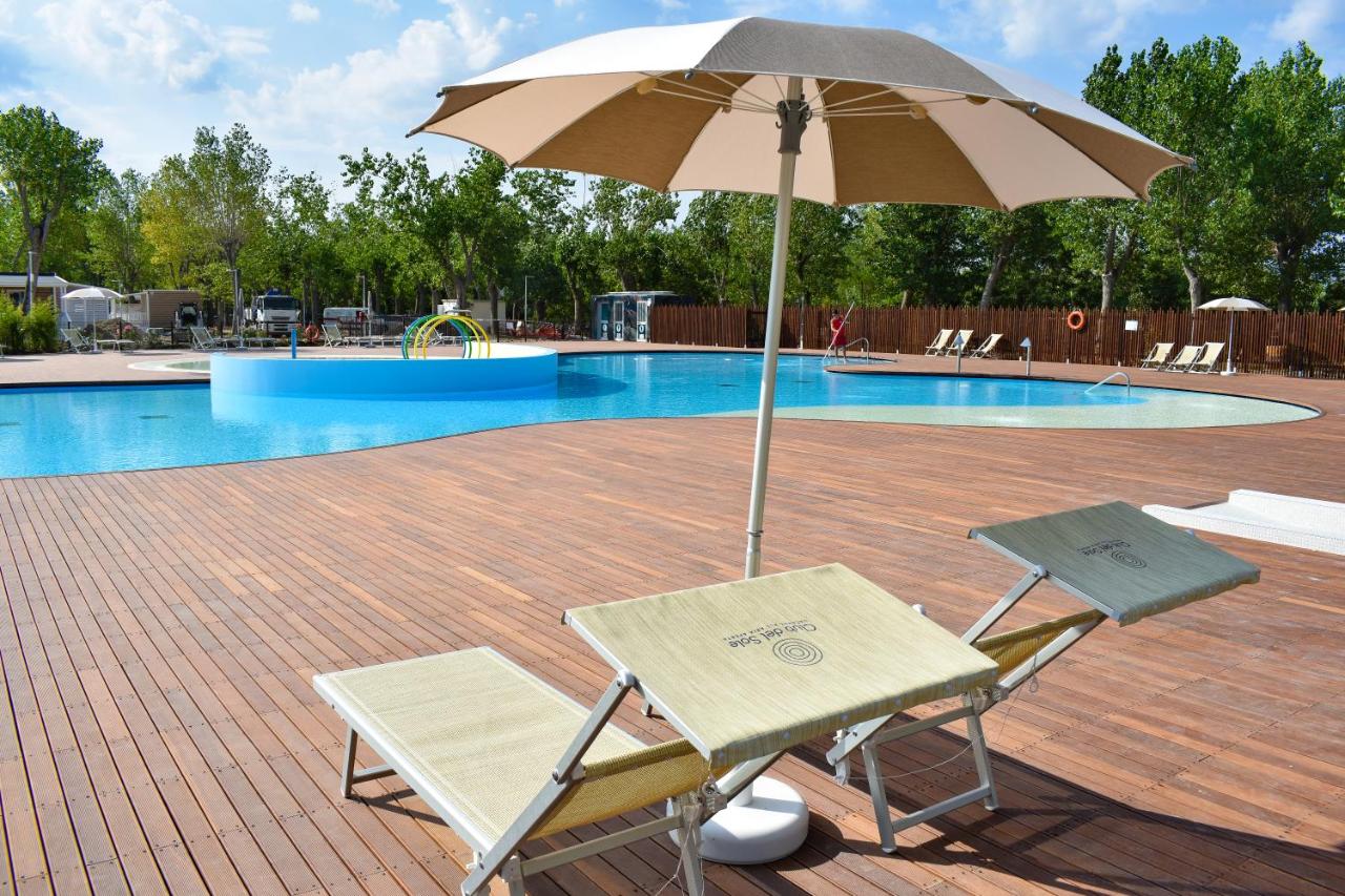 twee stoelen en een parasol voor een zwembad bij Club del Sole Rimini Family Resort in Rimini