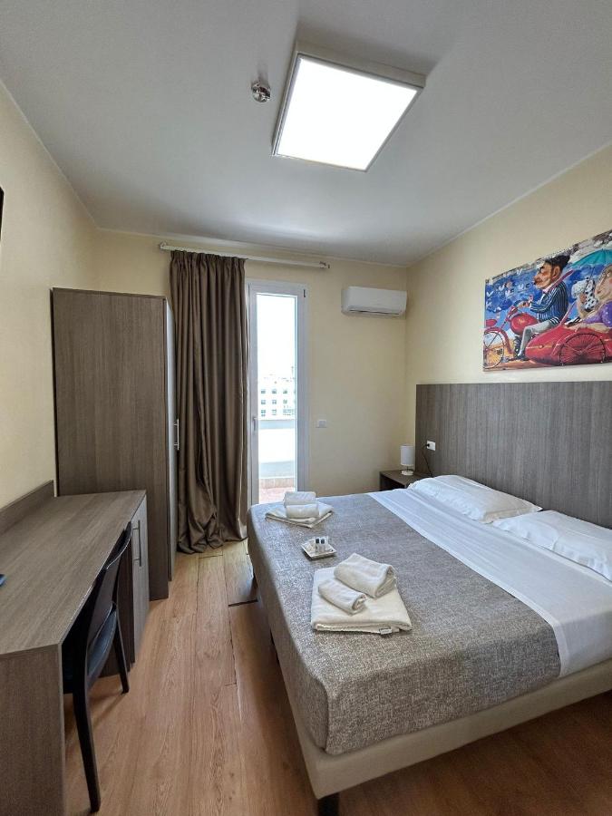 een slaapkamer met een bed, een bureau en een raam bij 55 Aira Hotel in Palermo