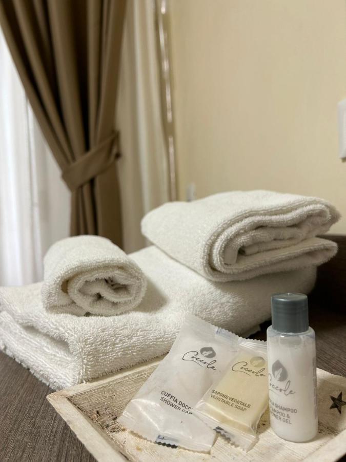 een badkamer met handdoeken en een fles lotion bij 55 Aira Hotel in Palermo