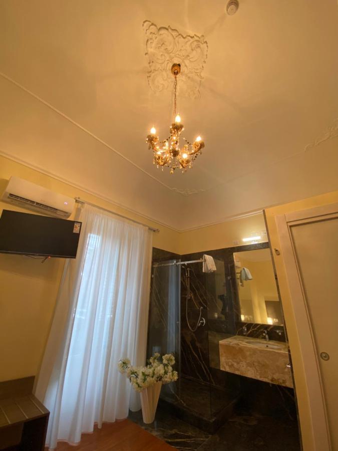 een badkamer met een kroonluchter aan het plafond bij 55 Aira Hotel in Palermo