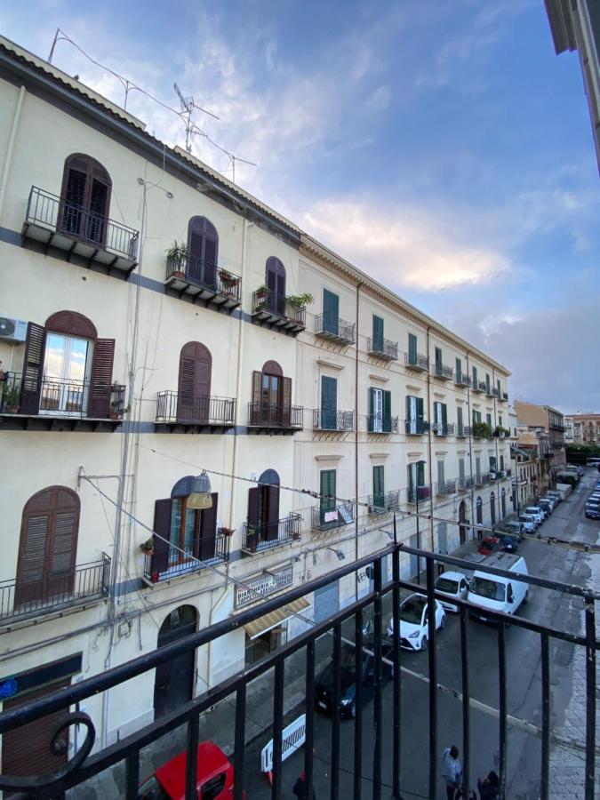 een groot wit gebouw met auto's geparkeerd op een parkeerplaats bij 55 Aira Hotel in Palermo