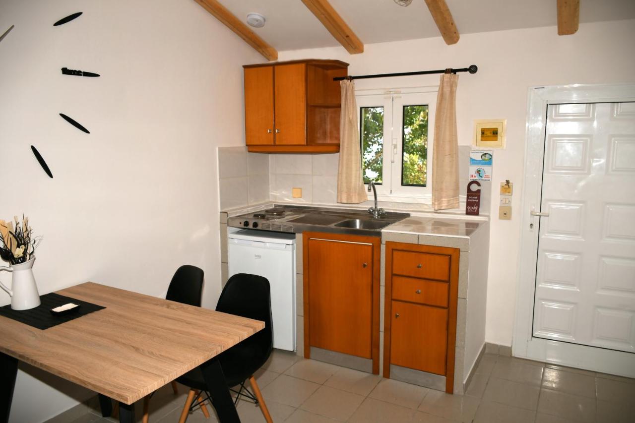een keuken met een tafel en een gootsteen en een tafel en stoelen bij Cavos Beach House in Kavos +61 foto's