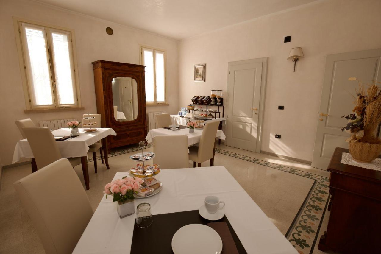 een eetkamer met tafels en stoelen en een spiegel bij B&B Residence il Ciliegio , Via Villa Superiore 93 Luzzara in Luzz