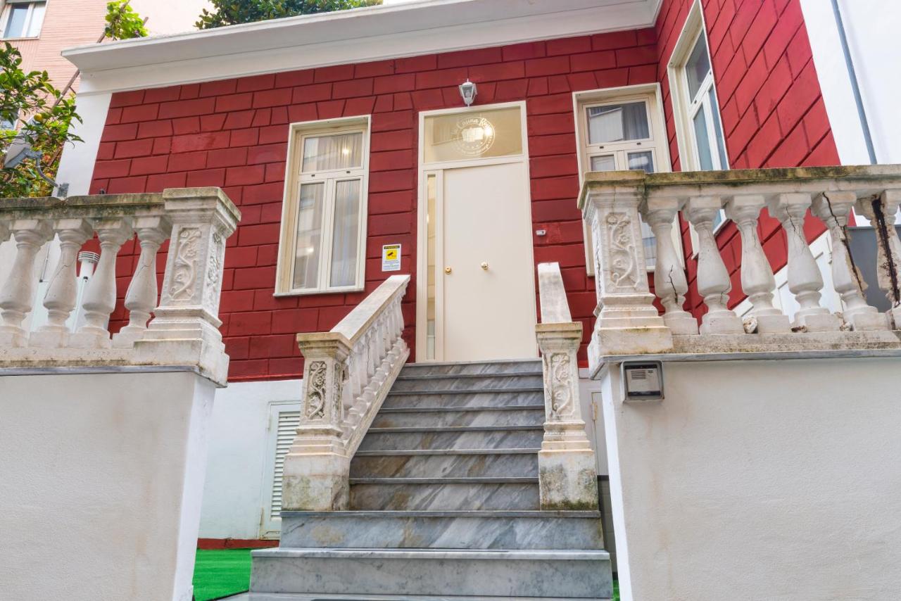een rood huis met een trap die naar een witte deur leidt bij La Casina Rossa in Napels
