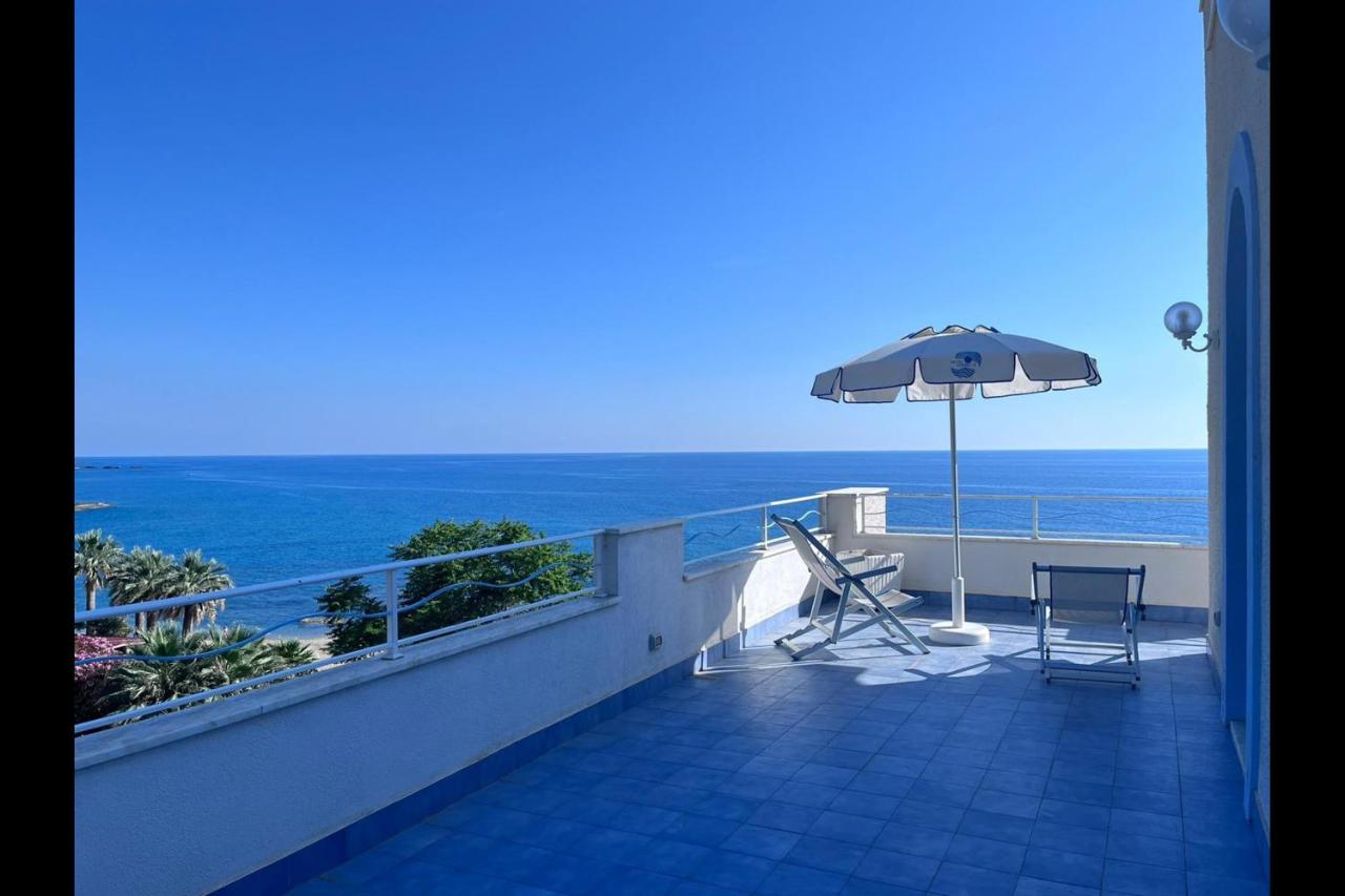 een balkon met een parasol, een tafel en stoelen bij Hotel Ferretti in Diamante
