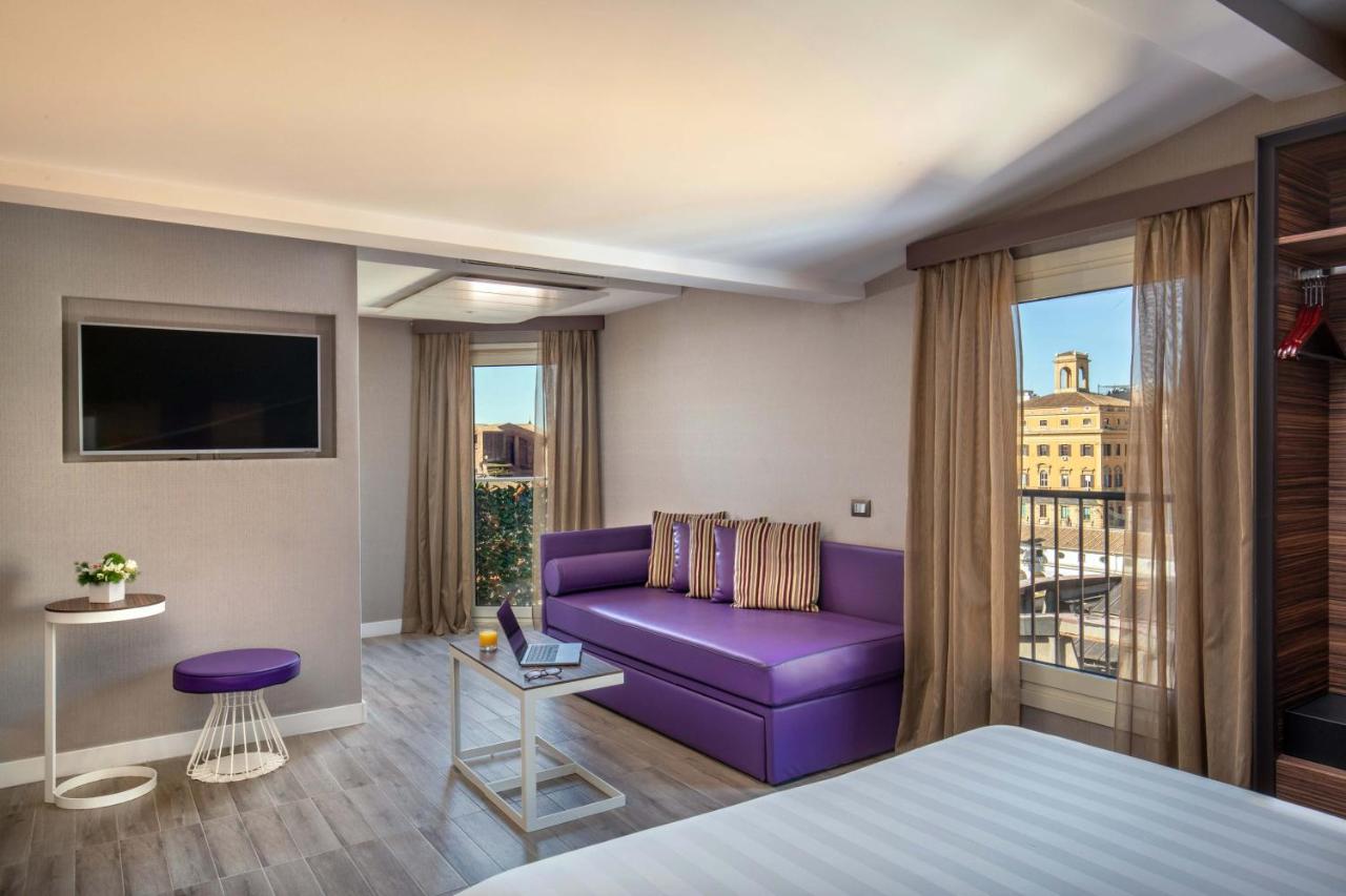 een hotelkamer met een paarse bank en een raam bij The Republic in Rome