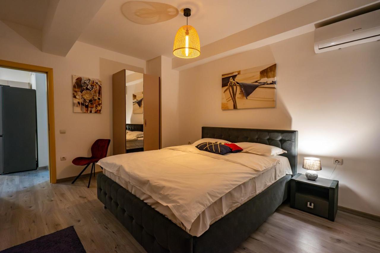 een slaapkamer met een groot bed en een lamp bij Sunny View Suites Mamaia by Moonlight Apartments in Mamaia