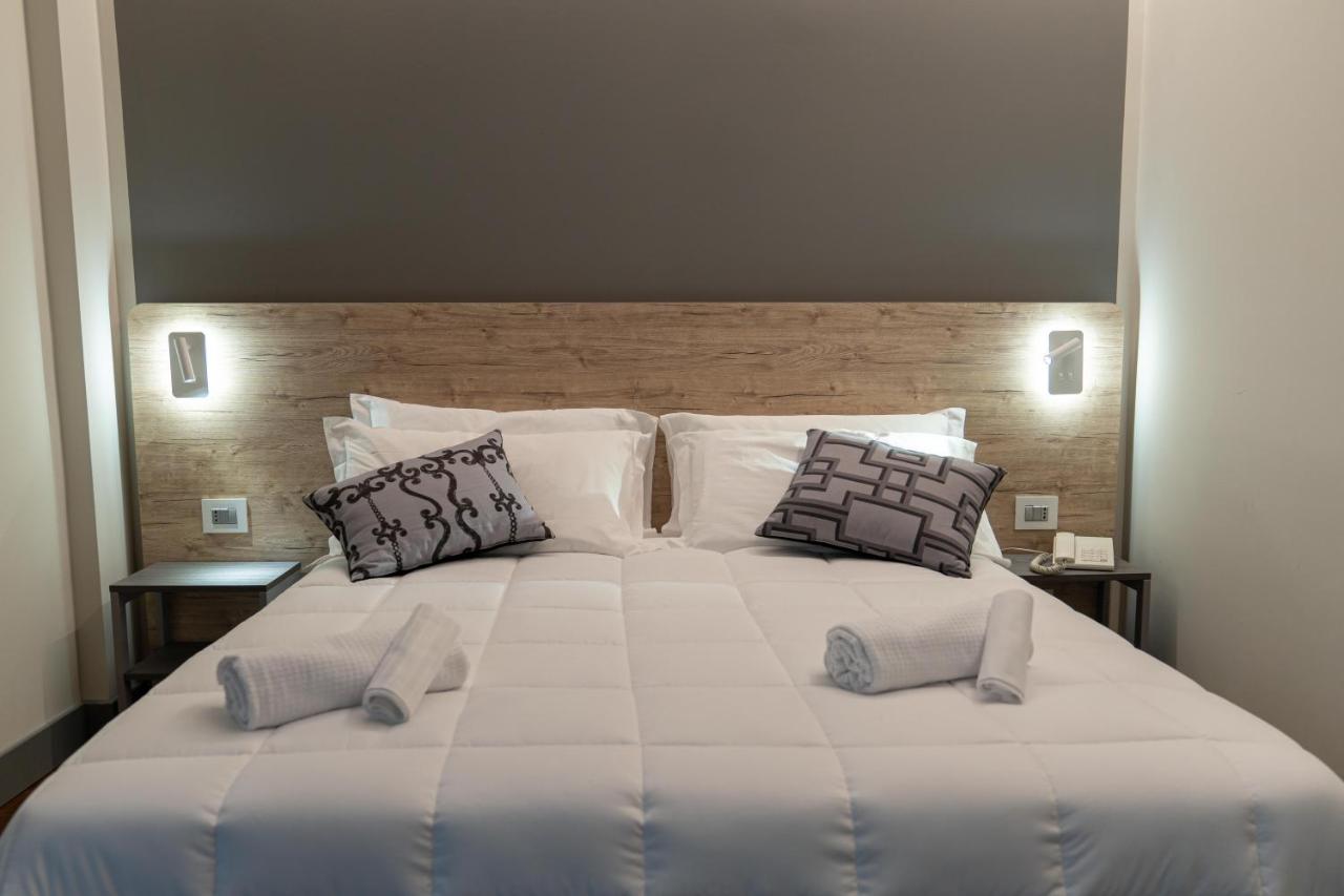 een groot wit bed met twee kussens erop bij Hotel Ambrosiano in Montecatini Terme