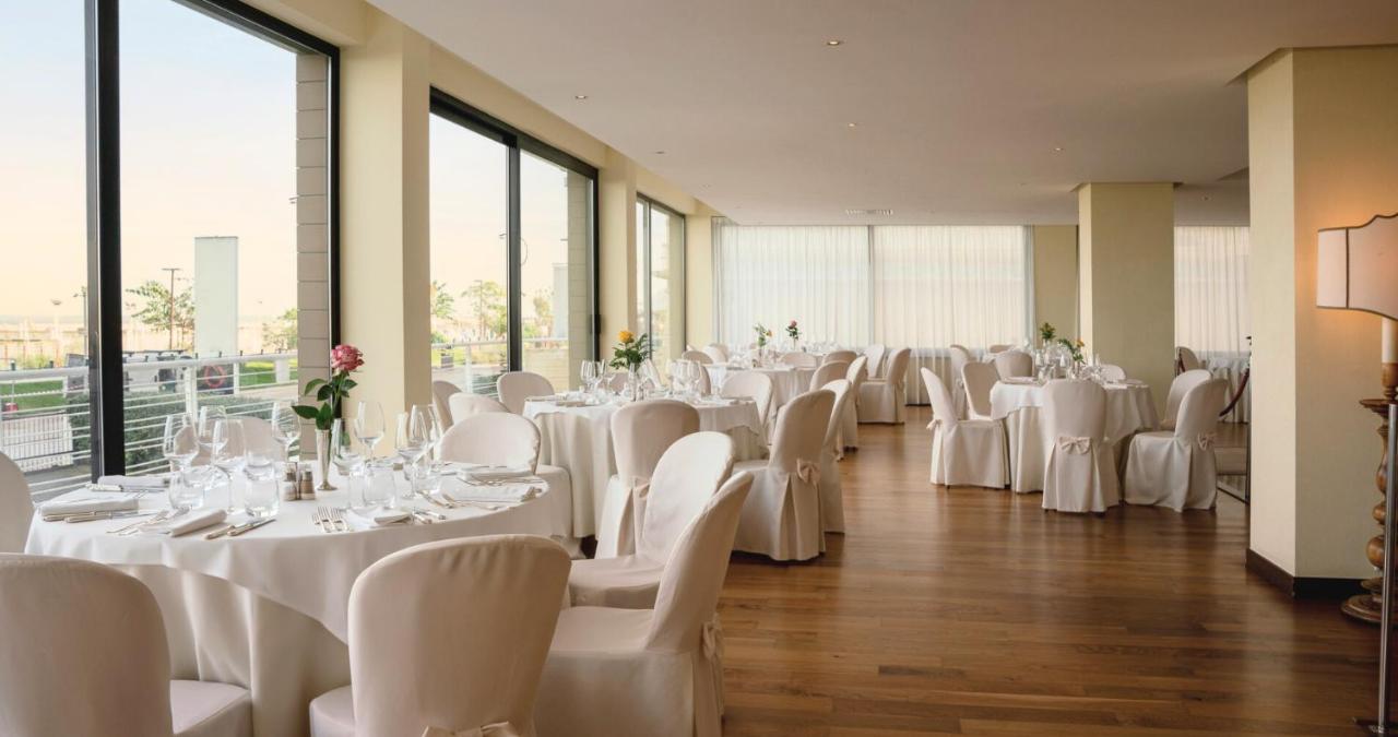 een feestzaal met witte tafels en witte stoelen bij National Hotel in Rimini +33 foto's