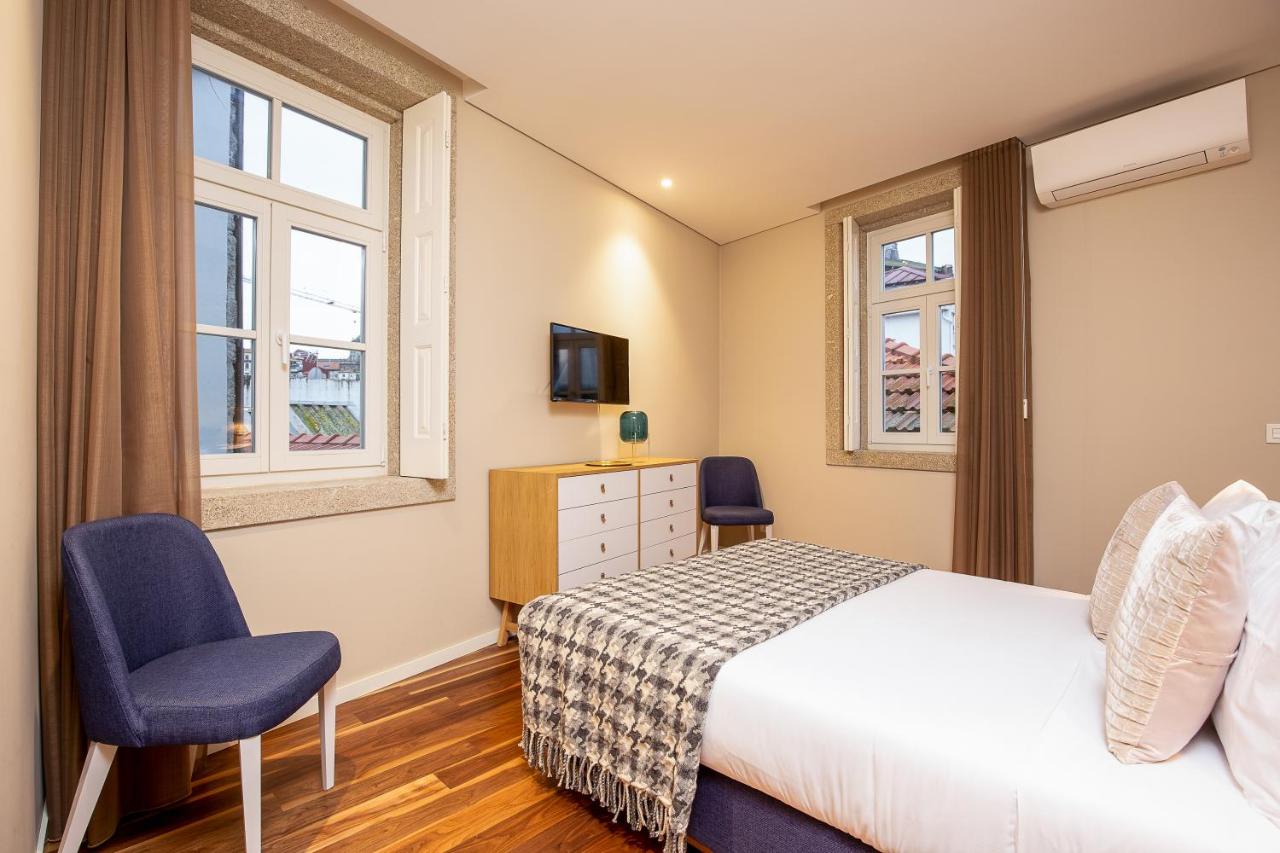 een slaapkamer met een bed en twee ramen bij RS Porto Historic Center in Porto