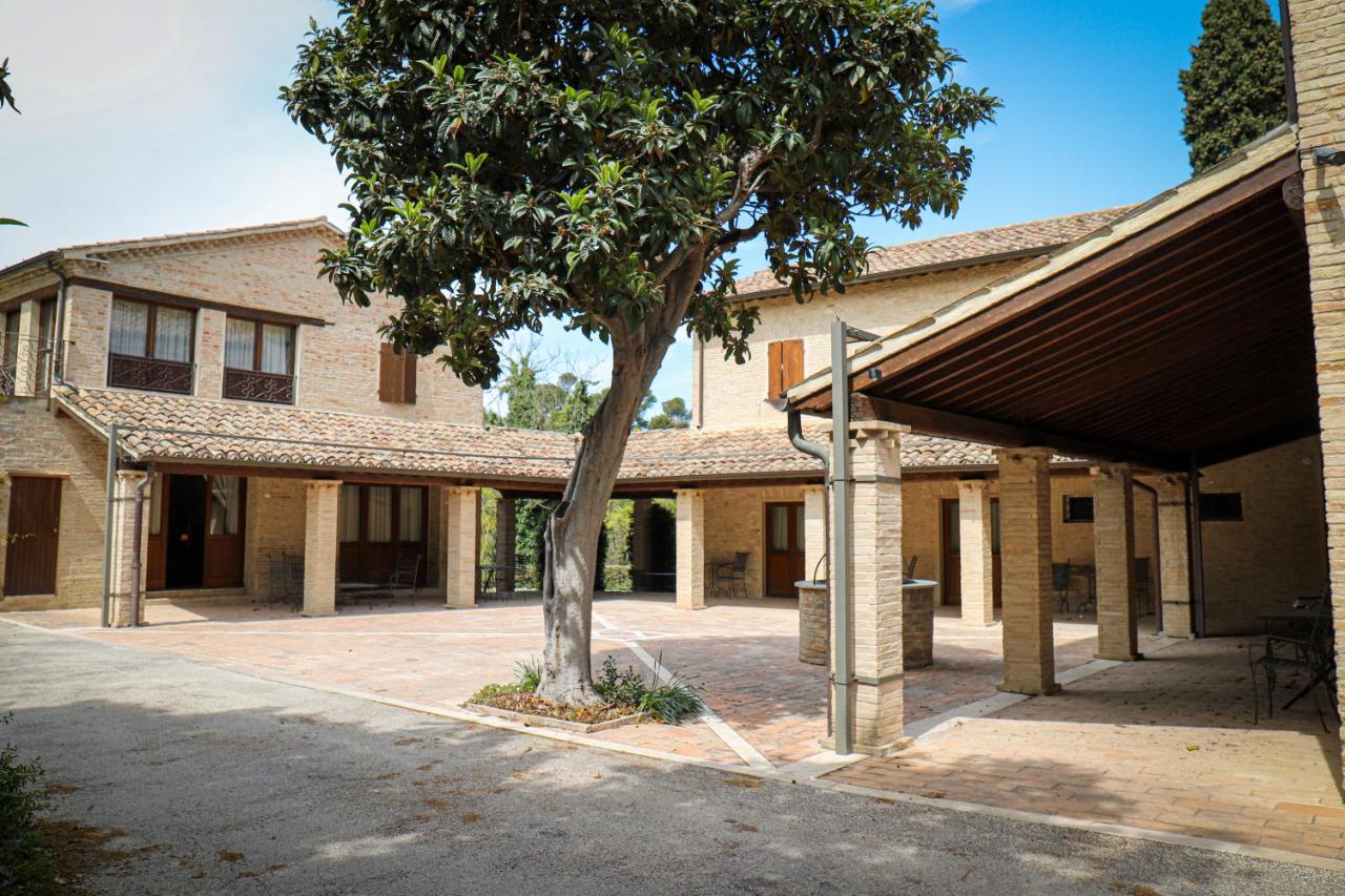 een gebouw met een boom ervoor bij Castello Montegiove in Fano