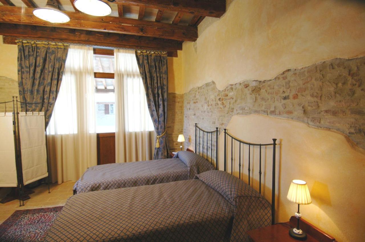 een slaapkamer met een bed, een bank en een raam bij Castello Montegiove in Fano