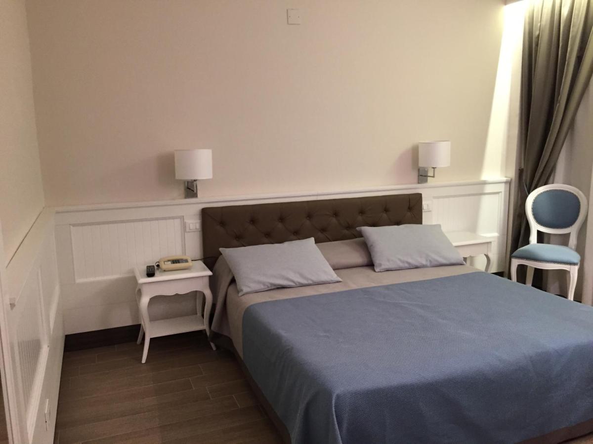 een kleine slaapkamer met een bed en een stoel bij Grand Hotel Montesilvano in Montesilvano