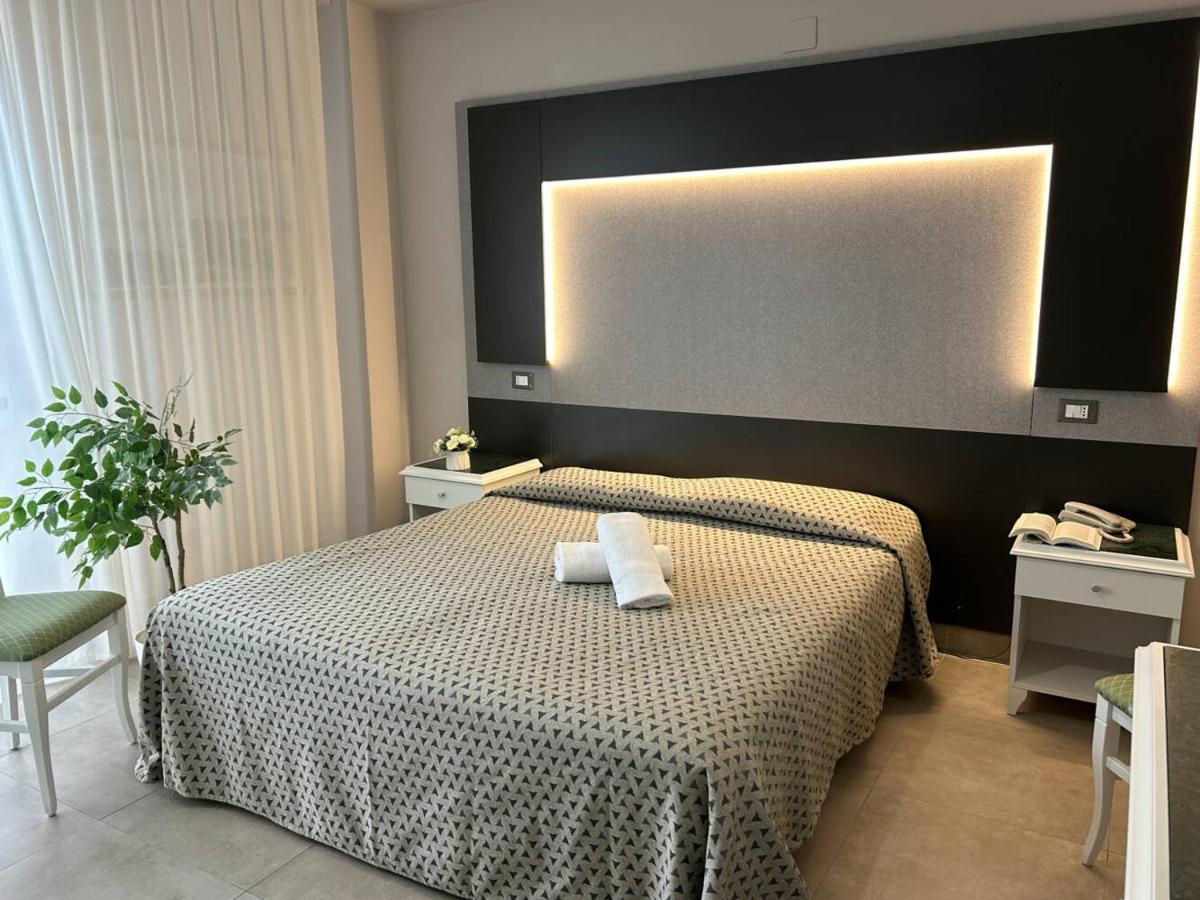 een slaapkamer met een bed waarop twee handdoeken liggen bij Grand Hotel Montesilvano in Montesilvano