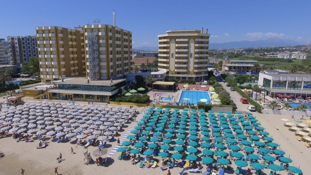 Een luchtfoto van een strand met parasols en een zwembad. bij Grand Hotel Montesilvano in Montesilvano